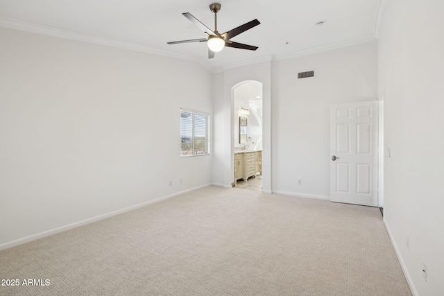 unfurnished bedroom with crown molding, ensuite bath, ceiling fan, and light carpet