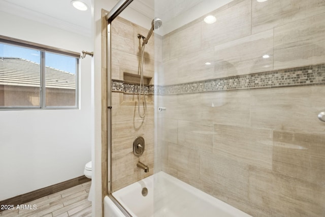 bathroom featuring bath / shower combo with glass door, crown molding, and toilet