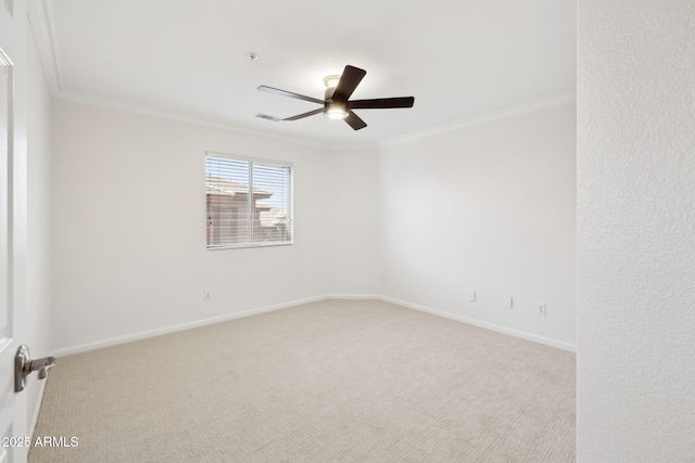 carpeted spare room featuring ceiling fan and ornamental molding