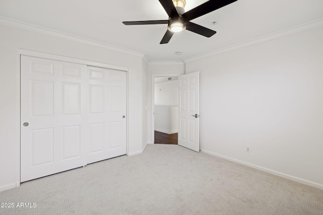 unfurnished bedroom with ceiling fan, light colored carpet, ornamental molding, and a closet