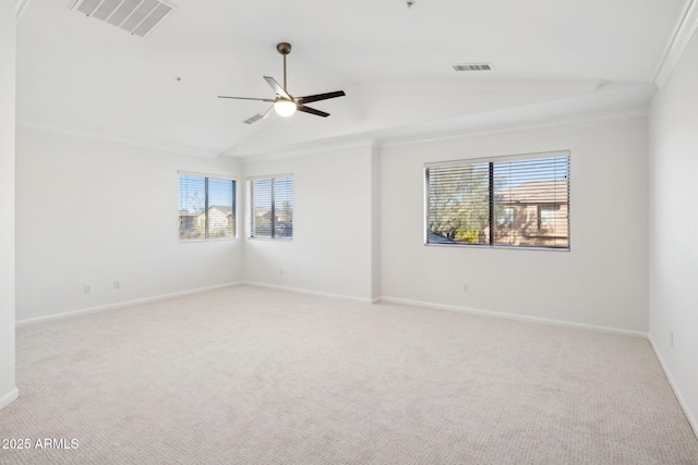 spare room with crown molding, a wealth of natural light, light colored carpet, and vaulted ceiling