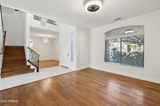 foyer entrance with ornamental molding and wood-type flooring