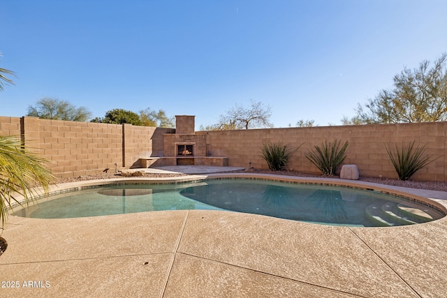 view of swimming pool featuring an outdoor fireplace