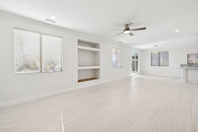 unfurnished living room with sink, built in shelves, ornamental molding, and ceiling fan