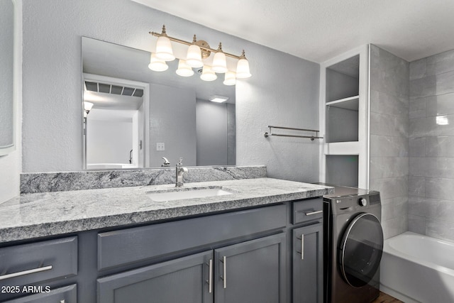 3416 N 44th St Unit 70, Phoenix, AZ 85018 - bathroom with washer / dryer, vanity, and a textured wall