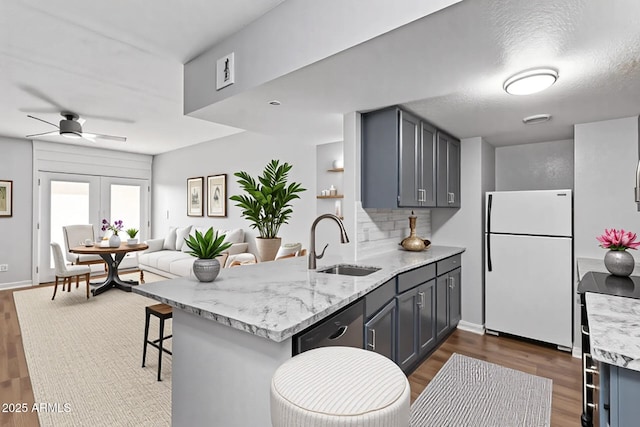 3416 N 44th St Unit 70, Phoenix, AZ 85018 - kitchen with freestanding refrigerator, a sink, a peninsula, dark wood-style floors, and decorative backsplash