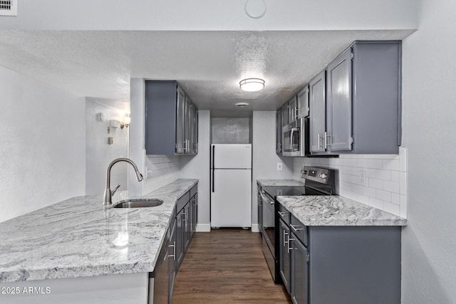 3416 N 44th St Unit 70, Phoenix, AZ 85018 - kitchen featuring appliances with stainless steel finishes, a sink, decorative backsplash, dark wood finished floors, and a textured ceiling