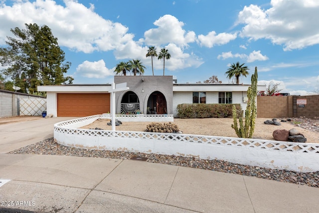 view of front of home featuring a garage, concrete driveway, brick siding, and fence