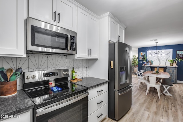 kitchen with a chandelier, stainless steel appliances, backsplash, and white cabinets