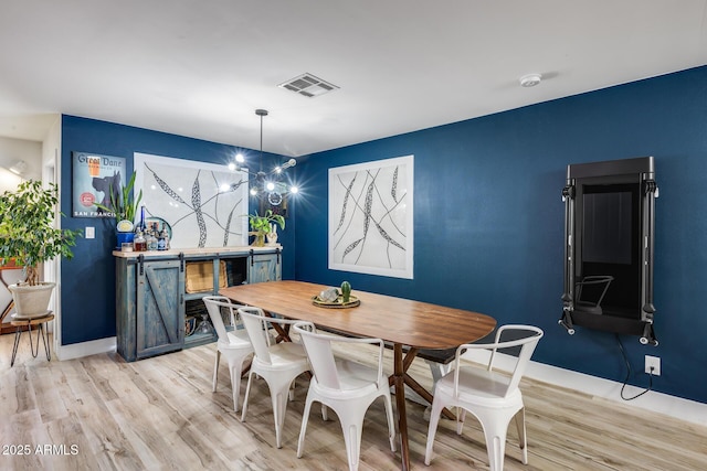 dining room with light wood-style floors, visible vents, a notable chandelier, and baseboards