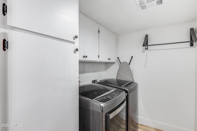 laundry room featuring visible vents, light wood-type flooring, independent washer and dryer, and cabinet space