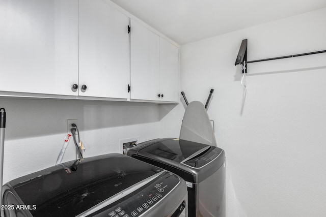 laundry room featuring independent washer and dryer and cabinet space