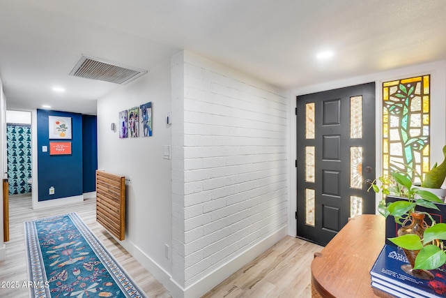 entrance foyer with light wood finished floors, baseboards, and visible vents