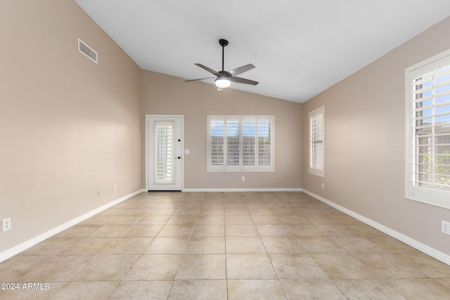 empty room with lofted ceiling, light tile patterned floors, and ceiling fan