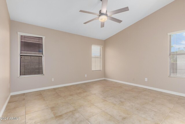 tiled spare room with ceiling fan, vaulted ceiling, and a healthy amount of sunlight