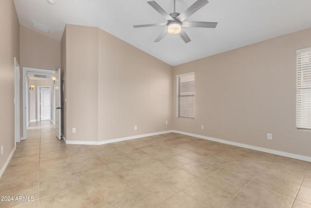 unfurnished room with light tile patterned floors, vaulted ceiling, and ceiling fan