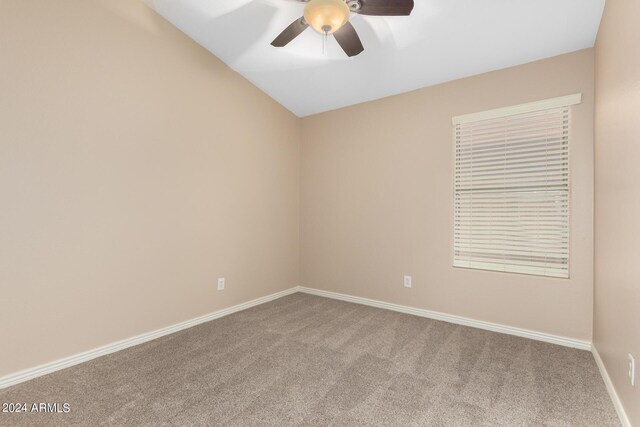 spare room with ceiling fan, vaulted ceiling, and carpet