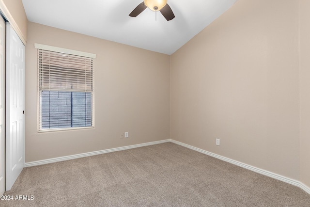 carpeted empty room with vaulted ceiling and ceiling fan