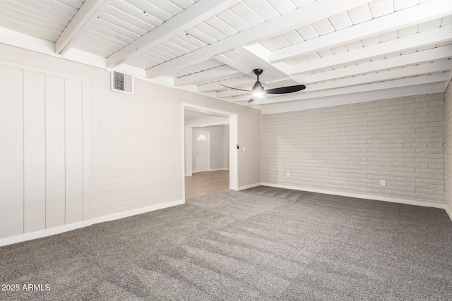 empty room featuring ceiling fan, brick wall, beamed ceiling, and carpet flooring