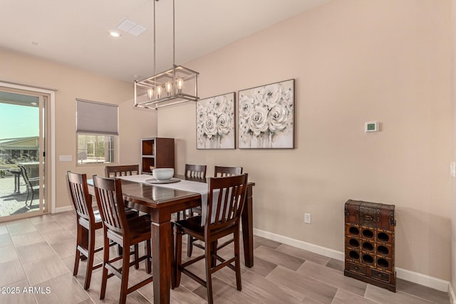 dining area featuring an inviting chandelier, visible vents, and baseboards