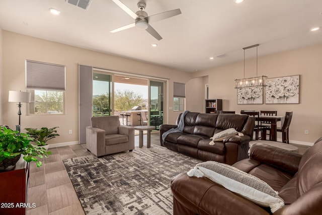 living area featuring recessed lighting, visible vents, baseboards, and ceiling fan with notable chandelier