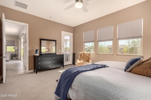 carpeted bedroom with baseboards, visible vents, and a ceiling fan