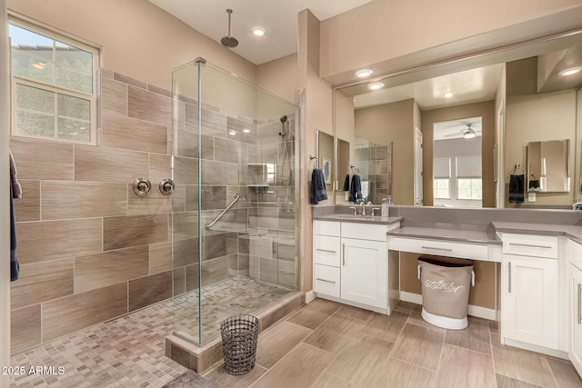 bathroom featuring a shower stall, a ceiling fan, and vanity