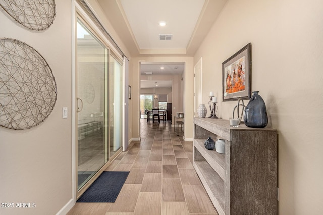 hallway with baseboards and visible vents