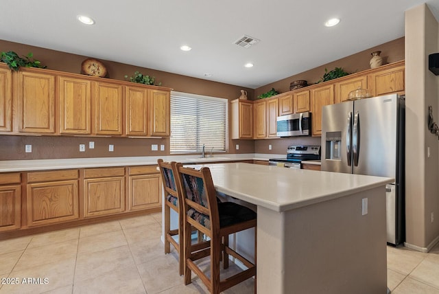40128 N Integrity Trl, Anthem, AZ 85086 - kitchen featuring stainless steel appliances, light countertops, recessed lighting, a kitchen island, and light tile patterned flooring