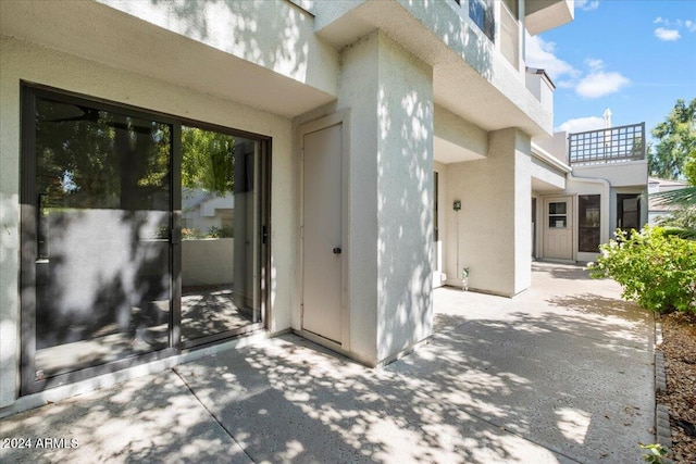 view of exterior entry with a patio