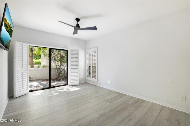 empty room with ceiling fan and light hardwood / wood-style flooring