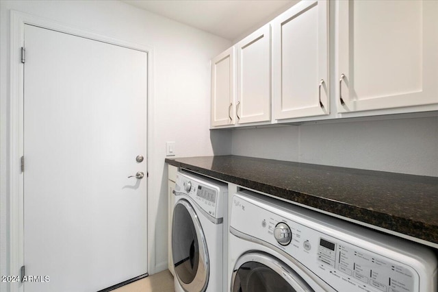 laundry area with separate washer and dryer and cabinets