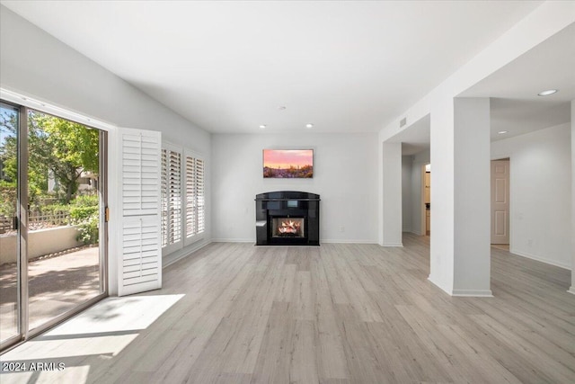 unfurnished living room with a wealth of natural light and light hardwood / wood-style flooring