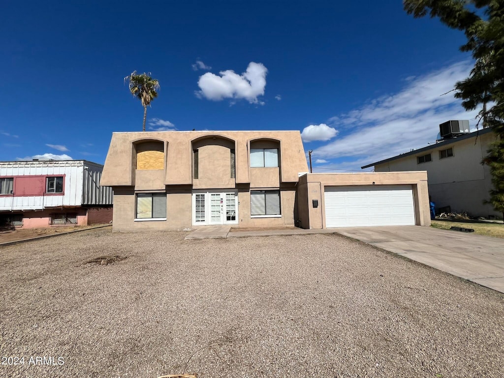 view of front of property featuring central AC unit and a garage