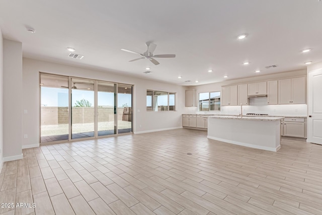 8553 N 175th Ln, Waddell, AZ 85355 - unfurnished living room with a ceiling fan, a sink, recessed lighting, baseboards, and light wood-style floors