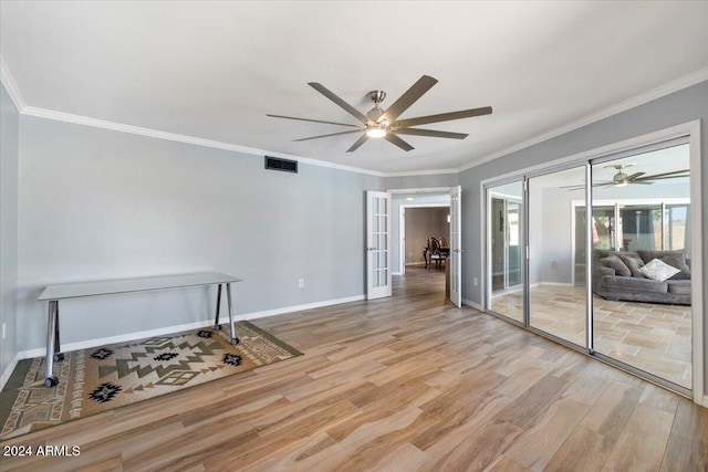 spare room featuring crown molding, light hardwood / wood-style floors, and french doors