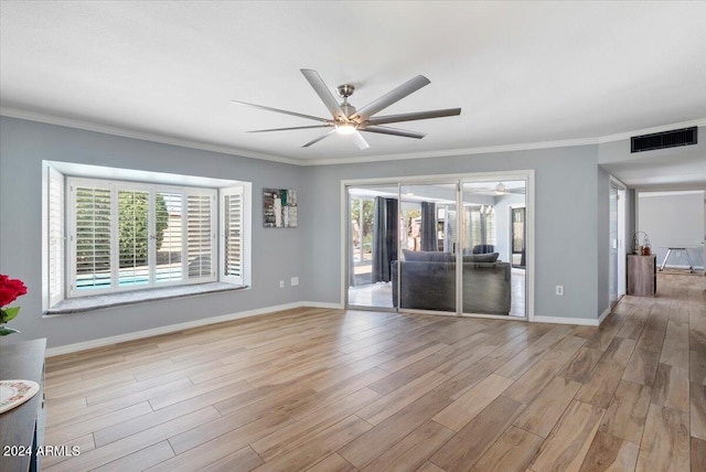 unfurnished room featuring light hardwood / wood-style floors, crown molding, and a healthy amount of sunlight