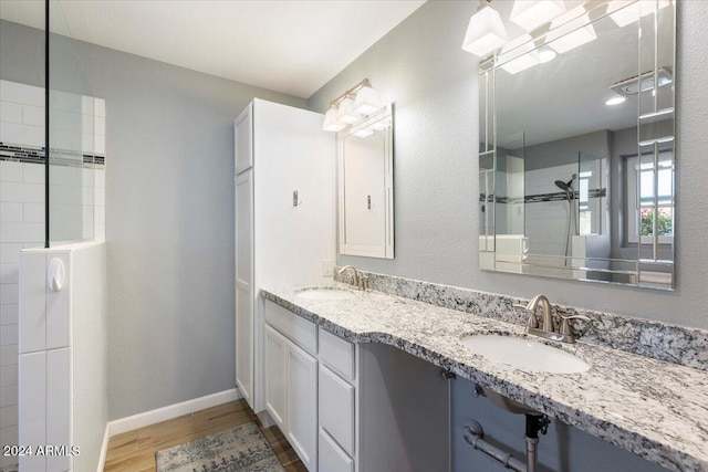 bathroom with vanity, wood-type flooring, and tiled shower