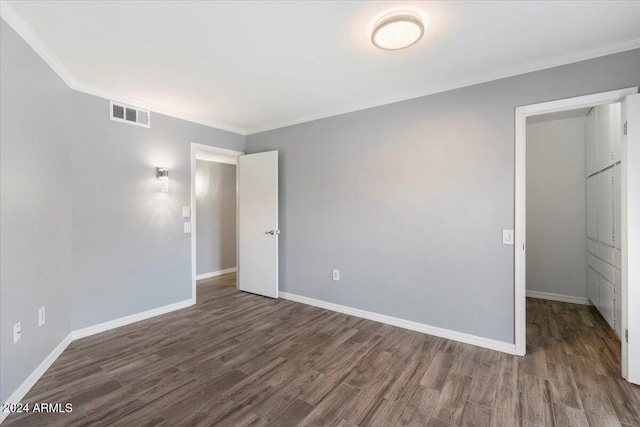 unfurnished bedroom with ornamental molding and dark hardwood / wood-style floors