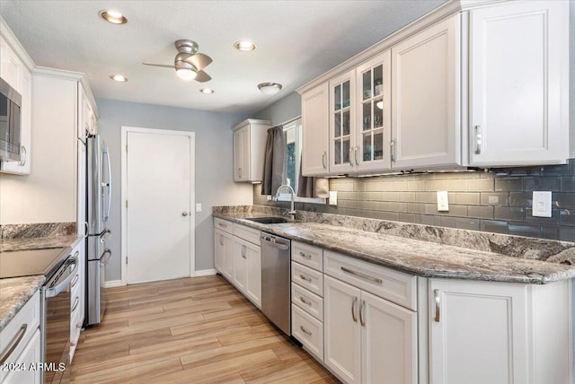 kitchen featuring appliances with stainless steel finishes, light stone counters, and white cabinetry