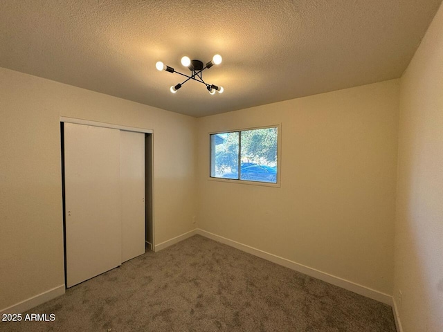 unfurnished bedroom with carpet floors, a closet, and a textured ceiling