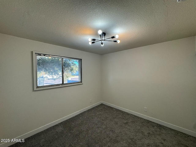 carpeted empty room featuring a textured ceiling