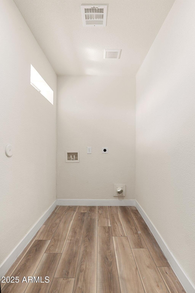 washroom featuring hardwood / wood-style flooring, washer hookup, and electric dryer hookup