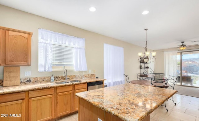 kitchen with ceiling fan with notable chandelier, a kitchen island, decorative light fixtures, sink, and stainless steel dishwasher