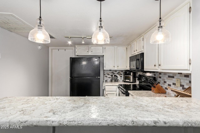 kitchen with white cabinets, hanging light fixtures, light countertops, black appliances, and tasteful backsplash