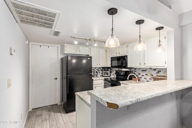 kitchen featuring tasteful backsplash, visible vents, light wood-type flooring, a peninsula, and black appliances