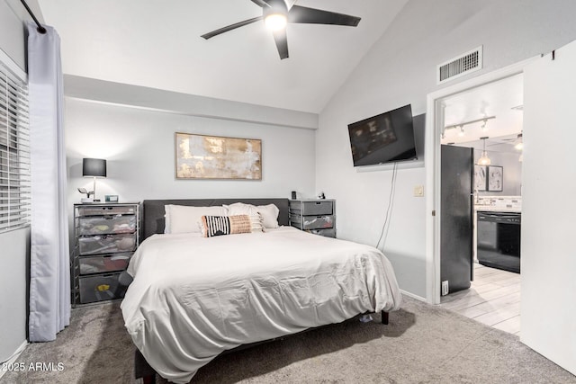 bedroom with visible vents, vaulted ceiling, freestanding refrigerator, carpet, and ensuite bath