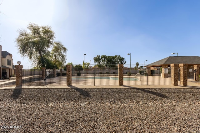 view of yard featuring a patio, fence, and a community pool