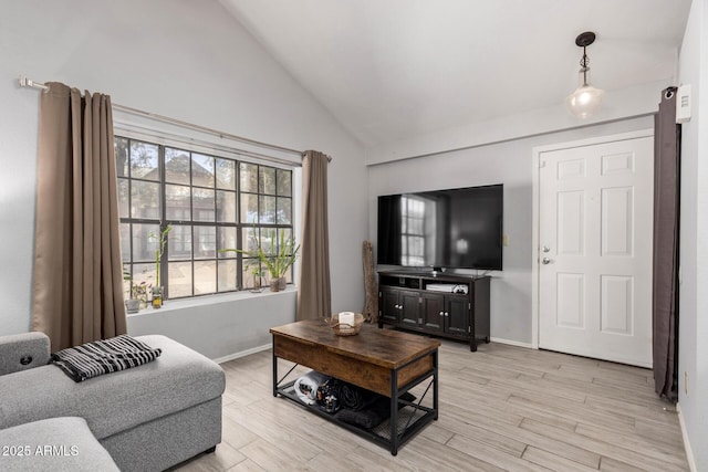 living room with light wood-style floors, lofted ceiling, and baseboards