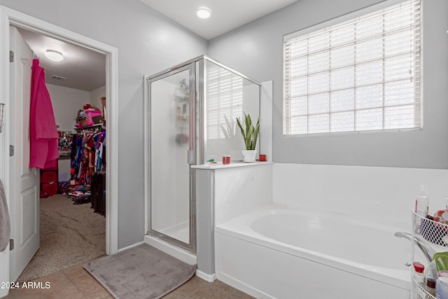 bathroom with shower with separate bathtub and tile patterned floors